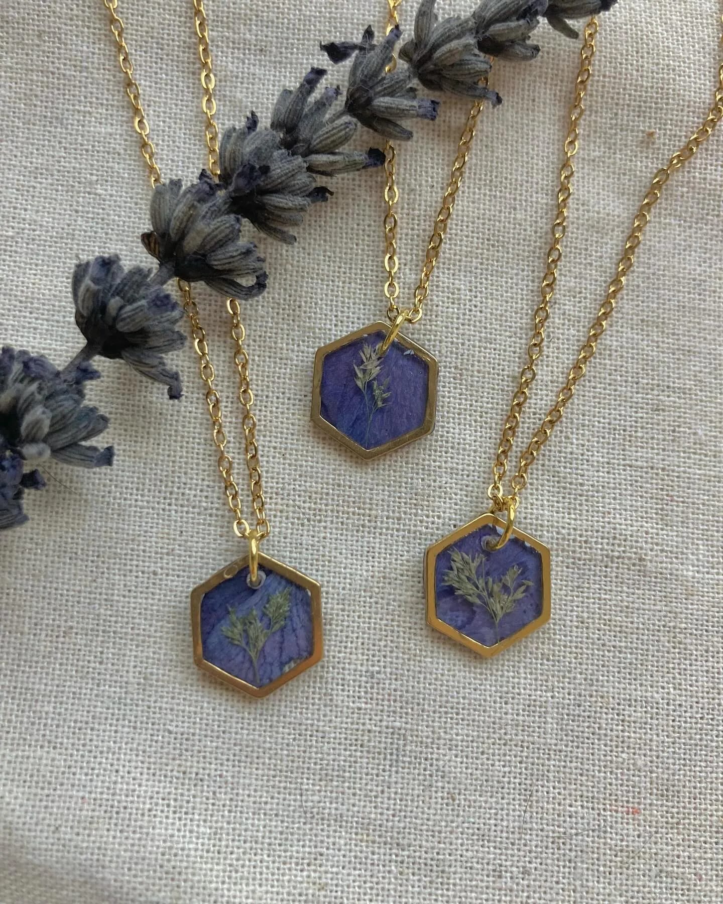 Tres colgantes hexagonales azules con lavanda seca sobre lino