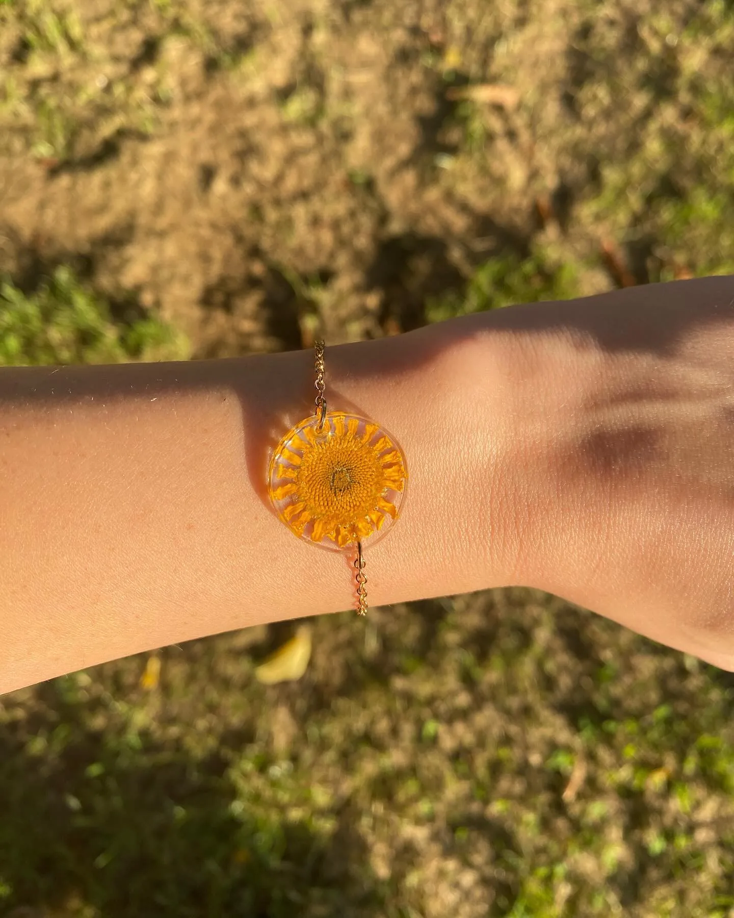Pulsera con una margarita naranja en la muñeca, al sol