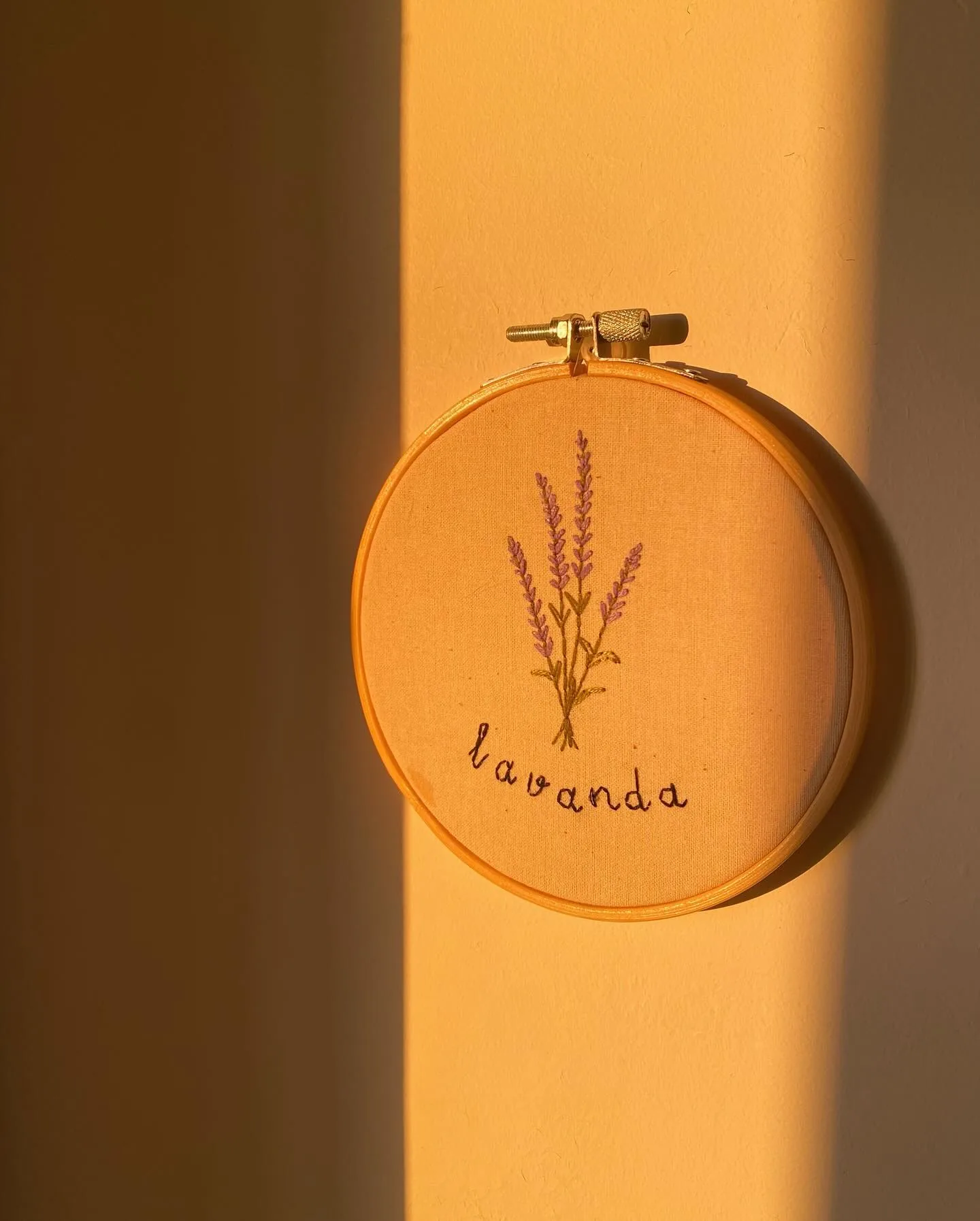 Bastidor con lavanda bordada y la palabra lavanda, con luz cálida